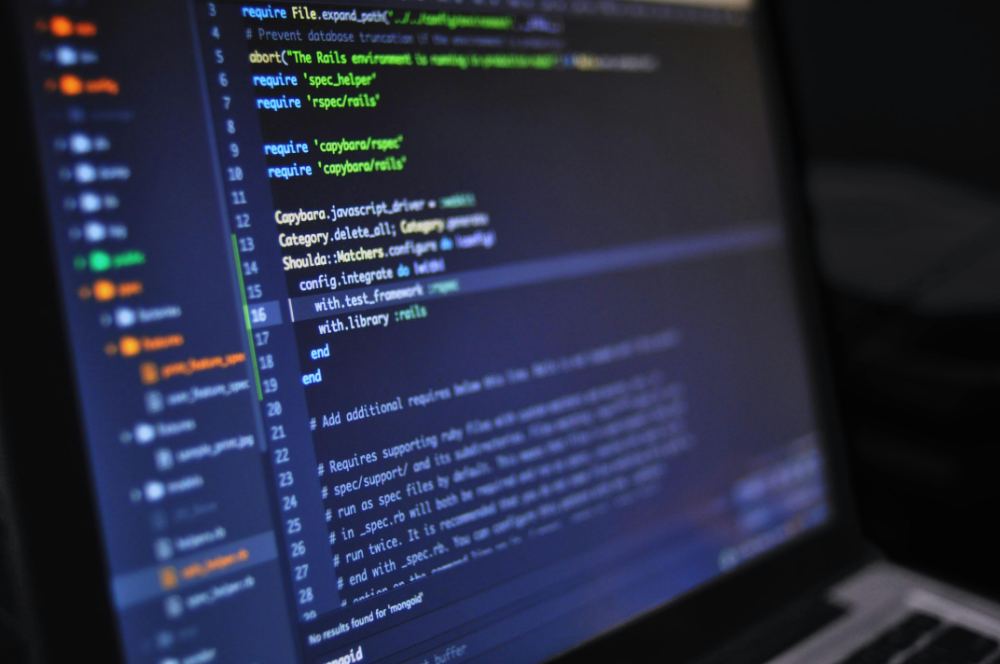 Source code on a laptop screen in a dark room